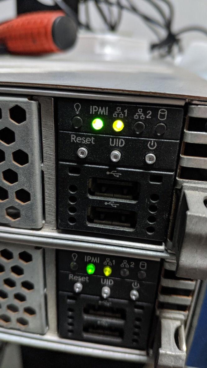 The front panel of a server with IPMI and network indicator lights on.